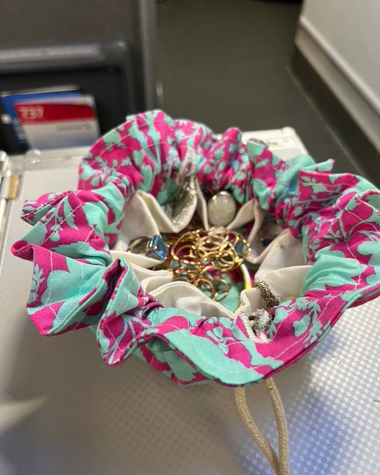 Wanderlust Jewelry Travel Pouch with drawstrings on airplane